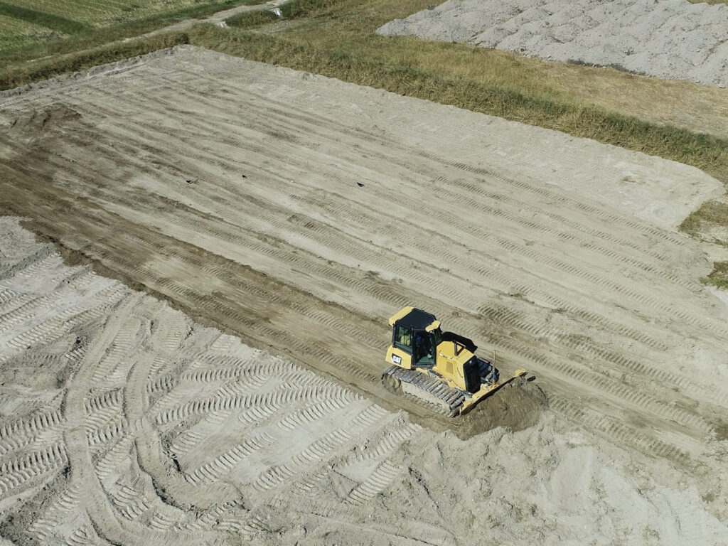 ブルドーザーで新たに整備された農地の耕土を水平に均しているところ。